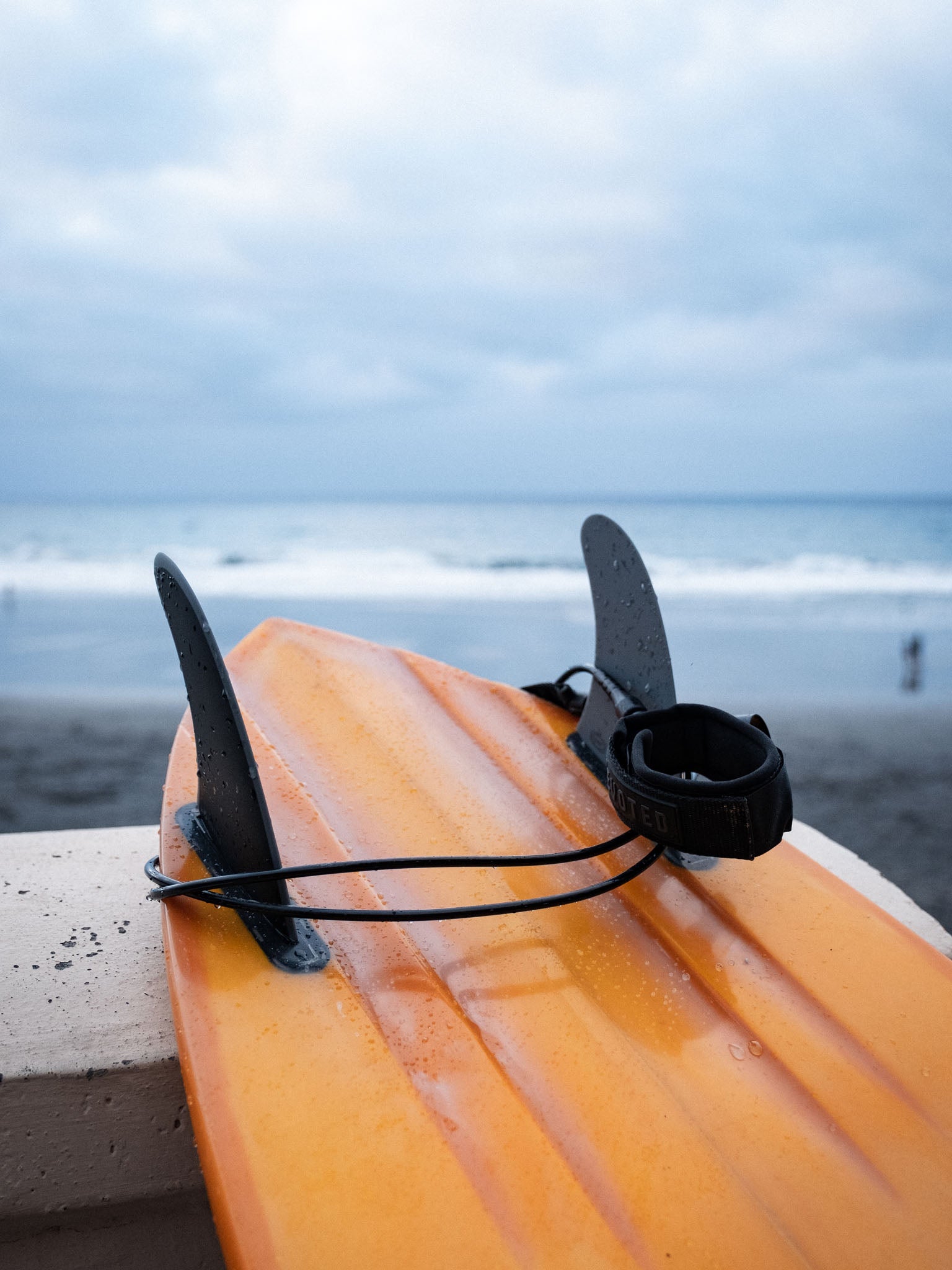 “Surfer preparing board with 7mm pro leash in outdoor setting”
