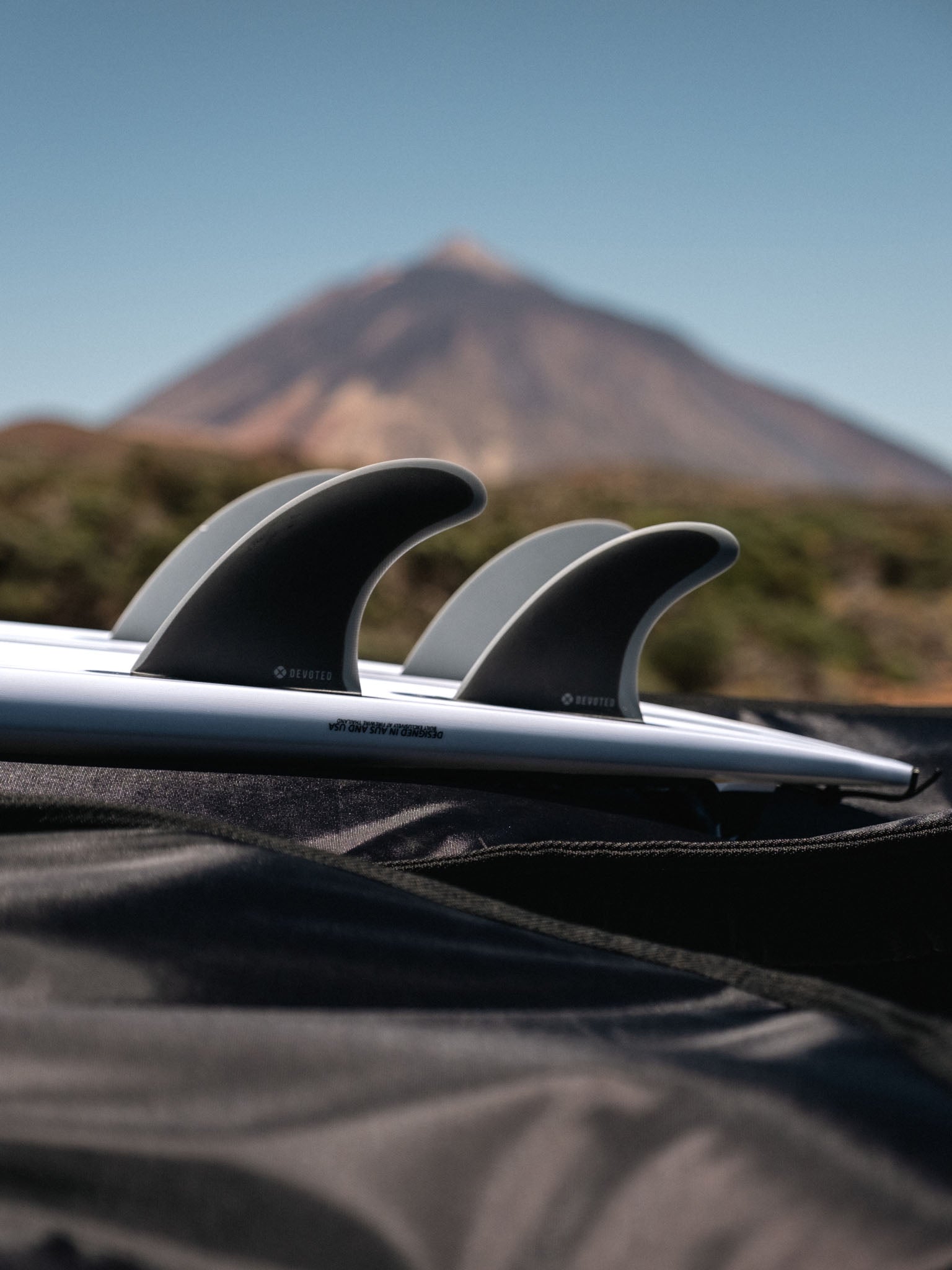 “CSF Quad dual-tab fibreglass fins on surfboard outdoors, highlighting rear and front fin placement”