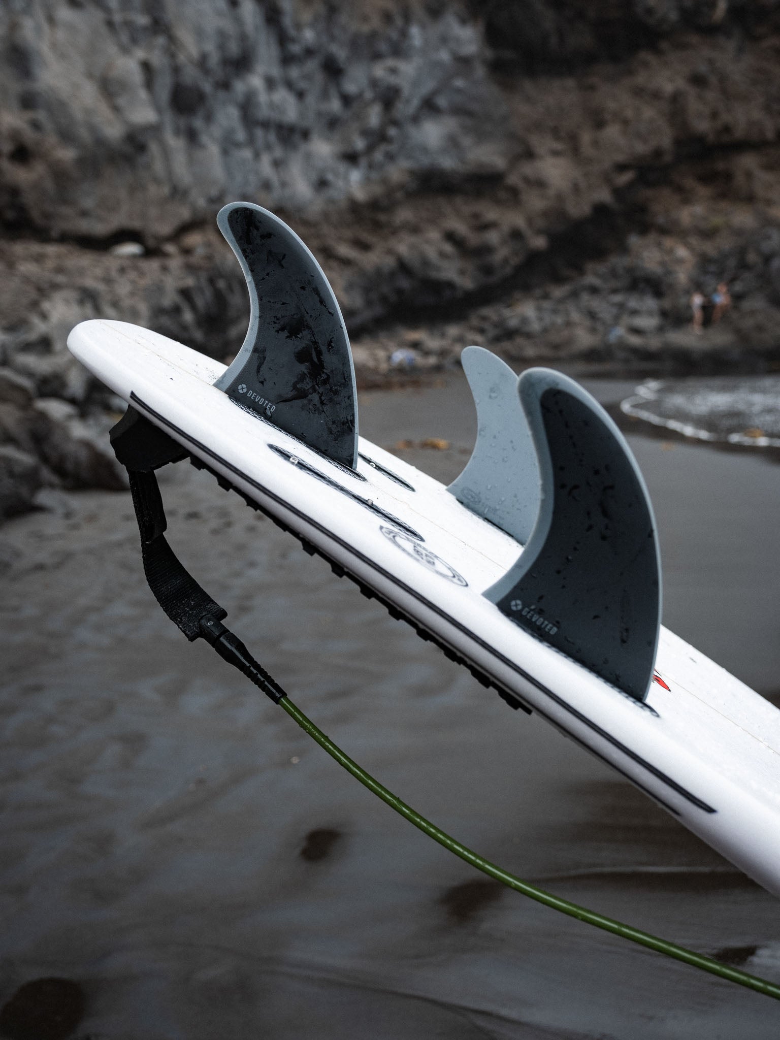 “CSF Thruster dual-tab fins on surfboard tail in natural setting, emphasizing balanced control design”
