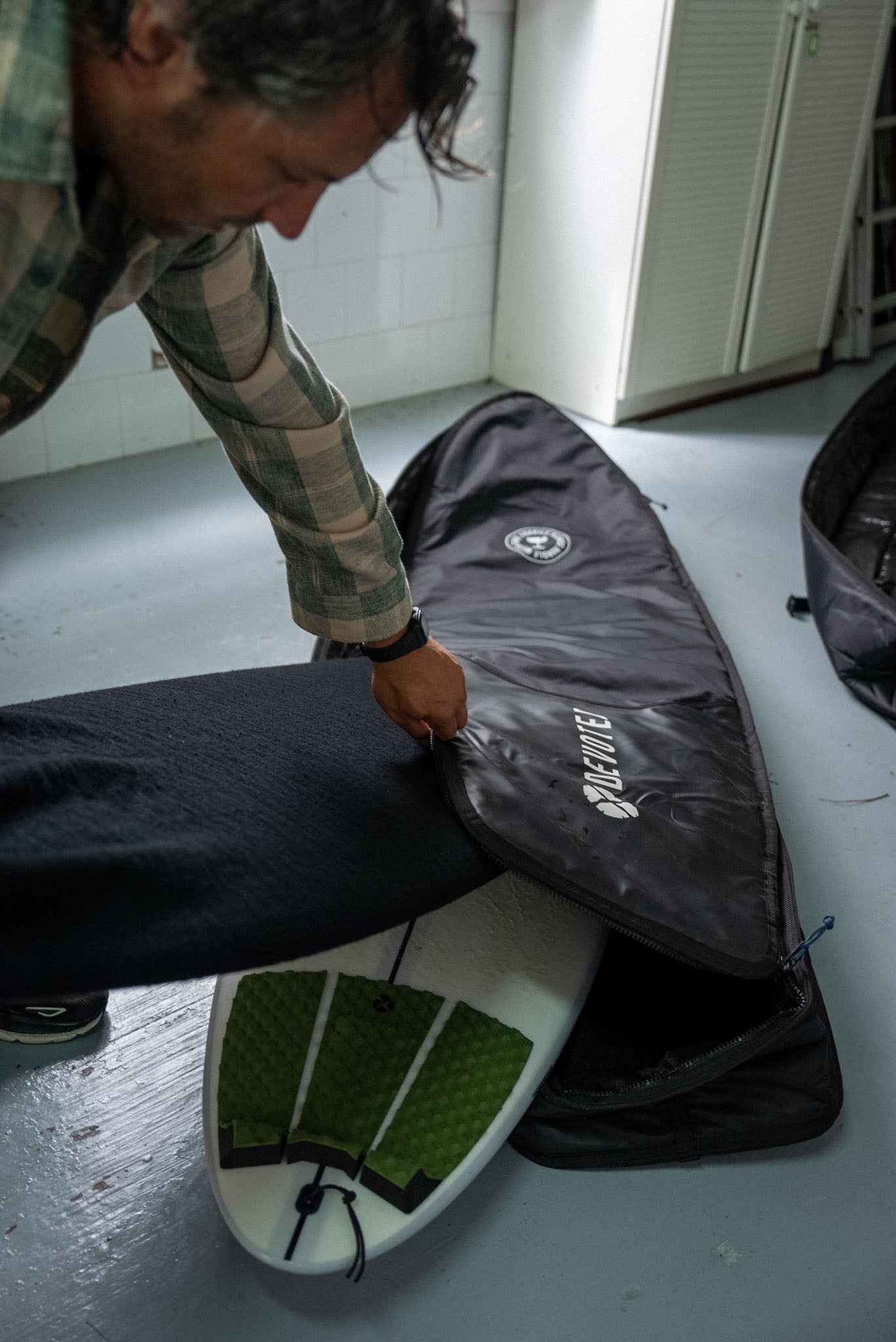 Fish 10mm Double Boardbag carried outdoors, showing travel-ready design and handles”