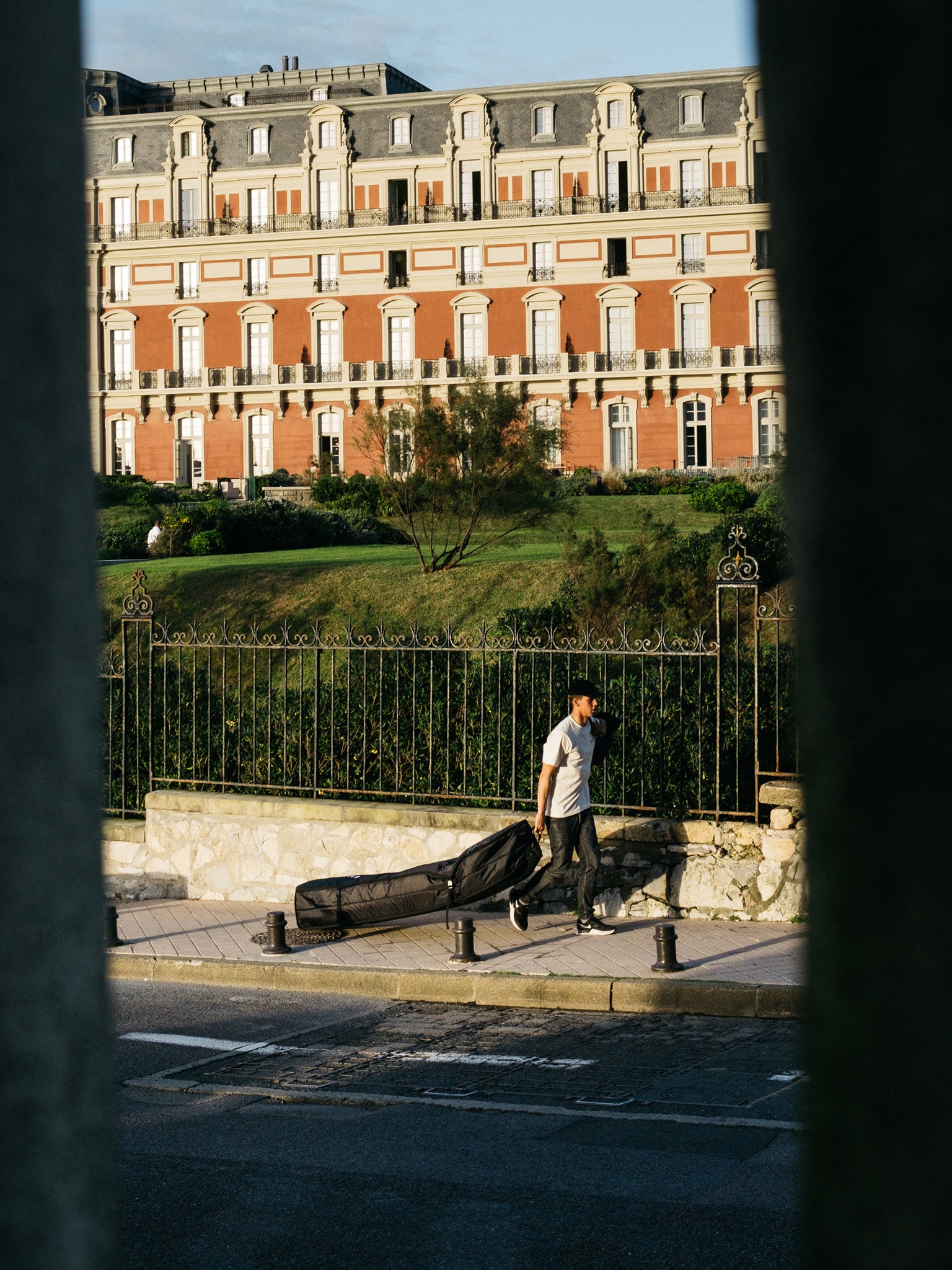 “Fish 10mm Quad Wheely Boardbag in outdoor use, being rolled across terrain with boards inside”
