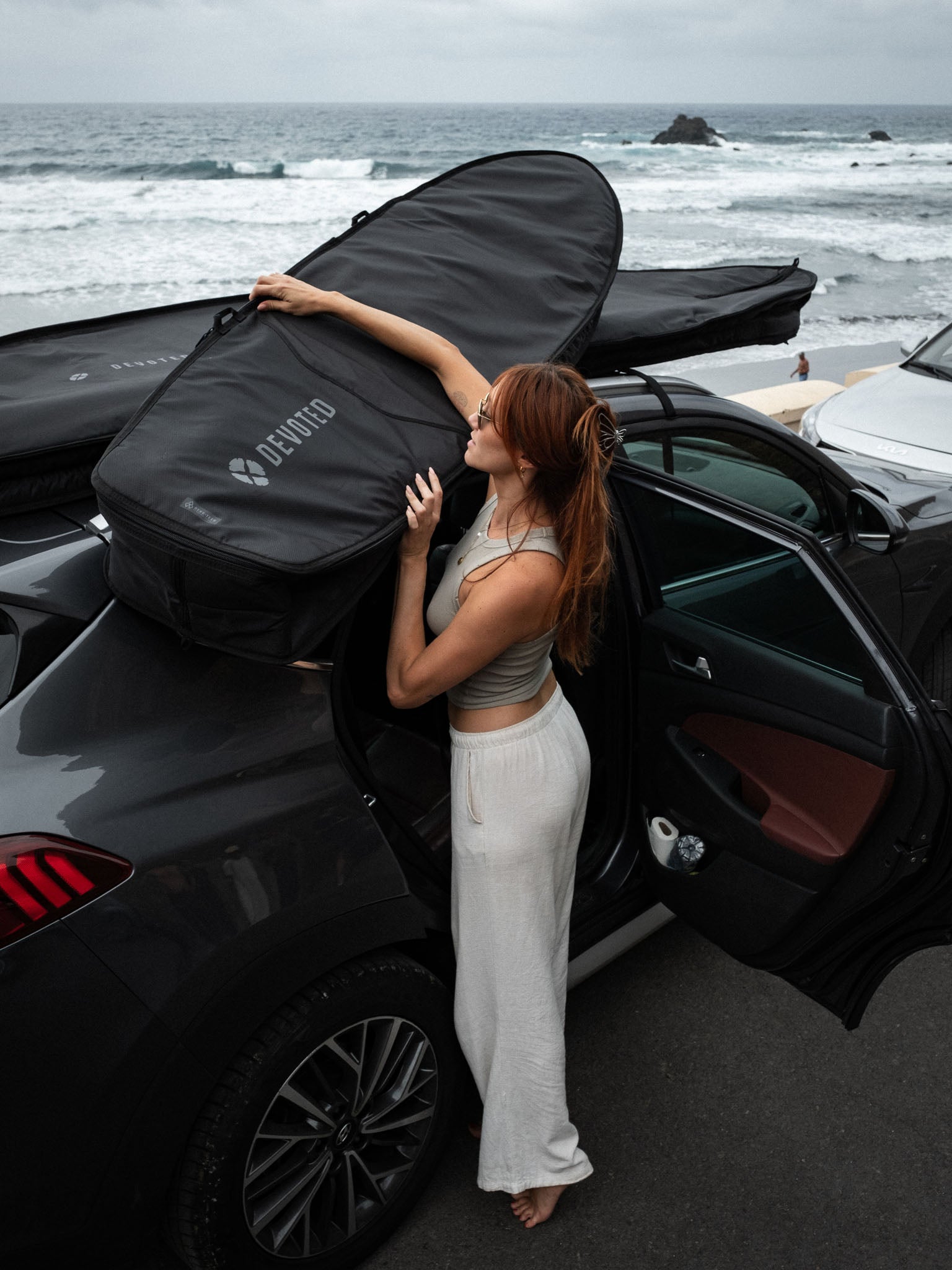 “Fish 8mm day boardbag outdoors, carried by surfer ready to hit the waves”
