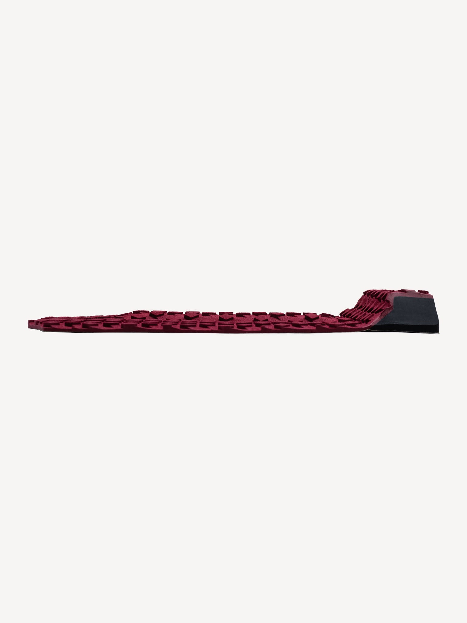 “Burgundy traction pad on surfboard in natural outdoor setting”
