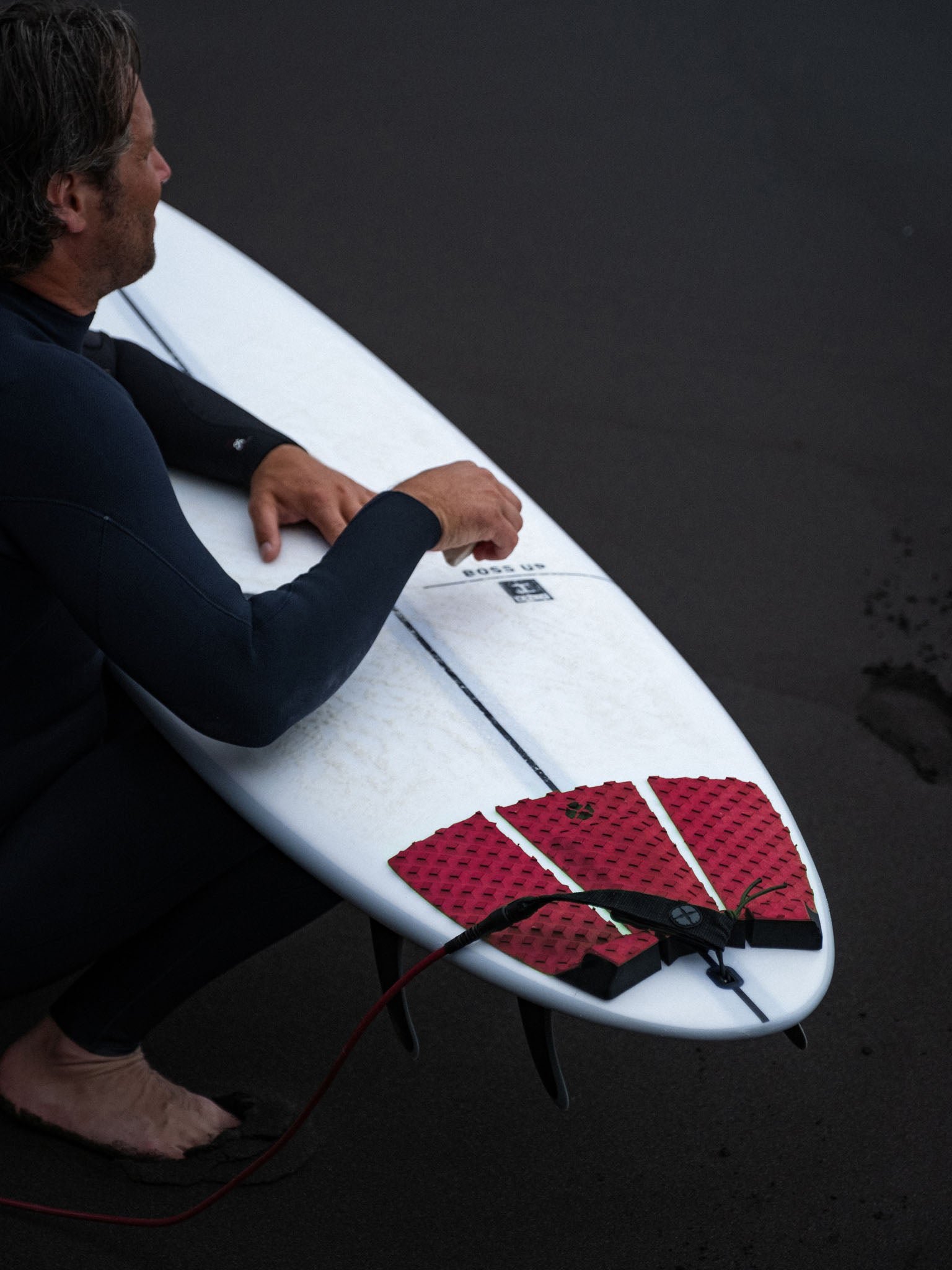 “Devoted Performance pad in use on surfboard near beach”
