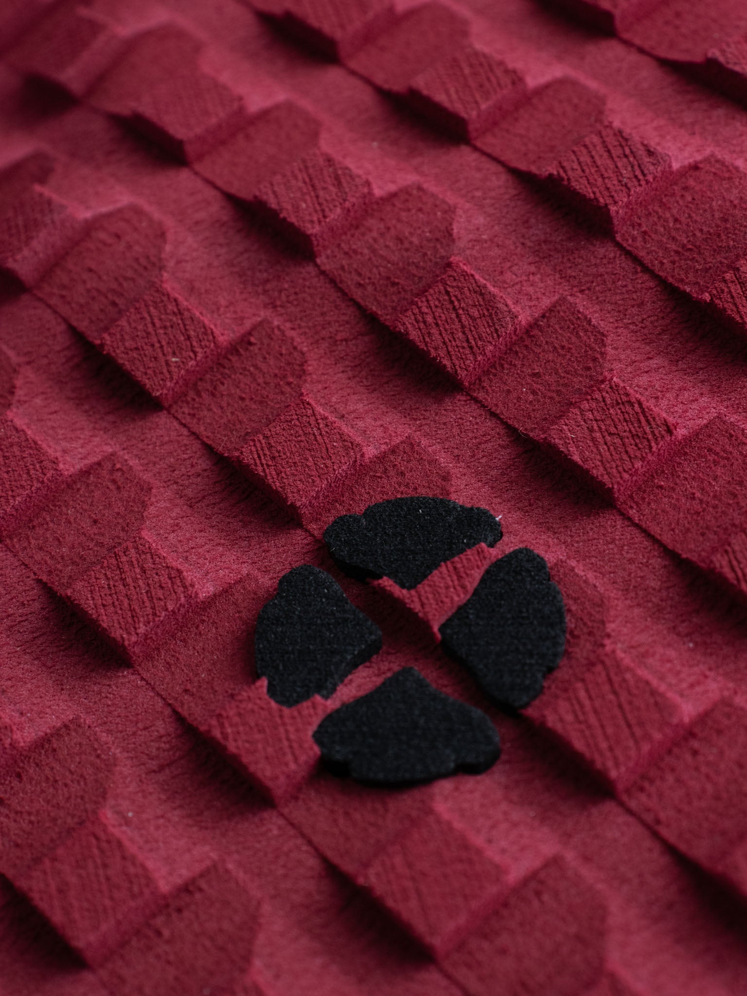 “Top-down view of 3-piece burgundy surf traction pad”
