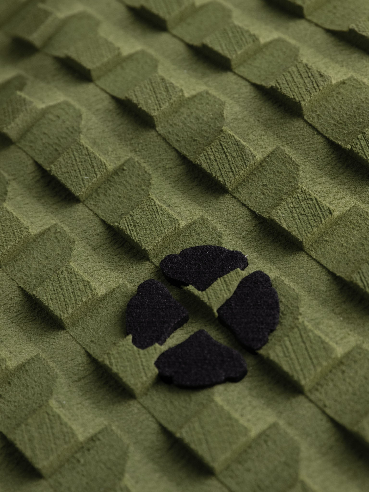 “Detailed top-down view of olive green surfboard grip pad”
